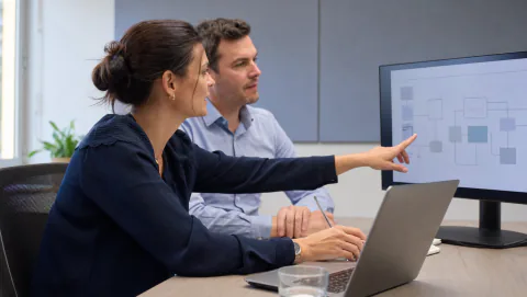 Consultante informatique expliquant un schéma d’architecture à un client
